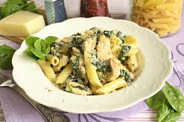 Makaron penne z kurczakiem i szpinakiem w sosie śmietanowym, podany pod chmurką parmezanu